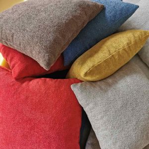 Dekorativni, ukrasni jastuci raznih boja na gomili