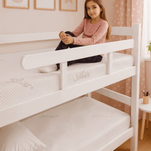 Devojčica sedi na krevetu na sprat u sobi