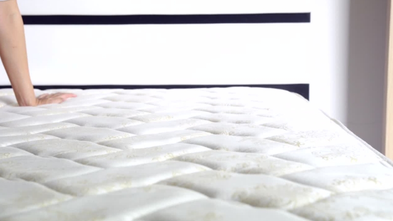 Osoba rukom isprobava tvrdoću dušeka pre kupovine