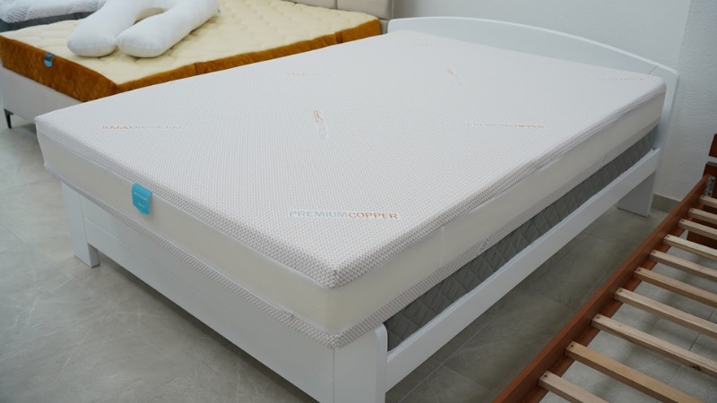 Moderan dušek sa oznakom „Premium Copper“ postavljen na beli drveni krevet