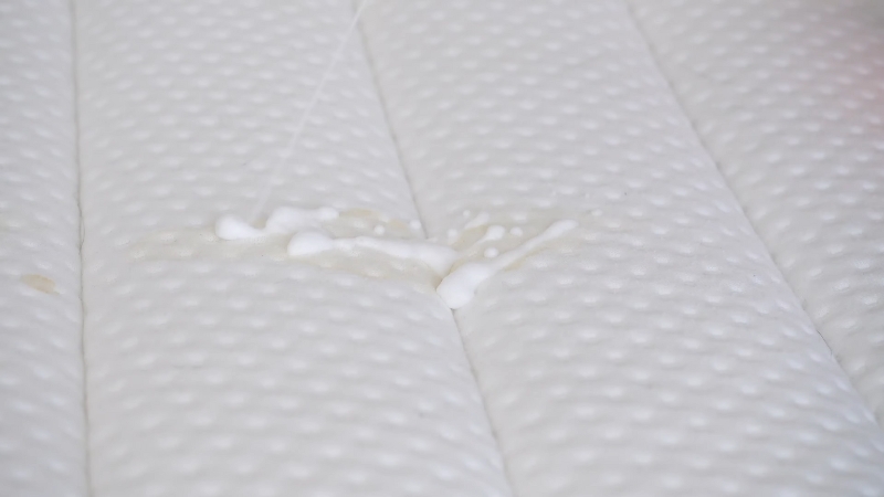 Osoba čisti dušek od fleka