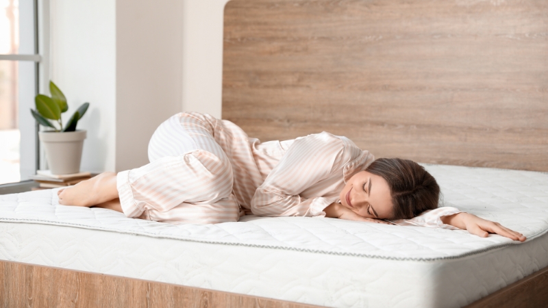 Žena spava na tvrdom dušeku na krevetu u spavaćoj sobi