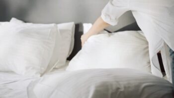Osoba menja jastuk na krevetu